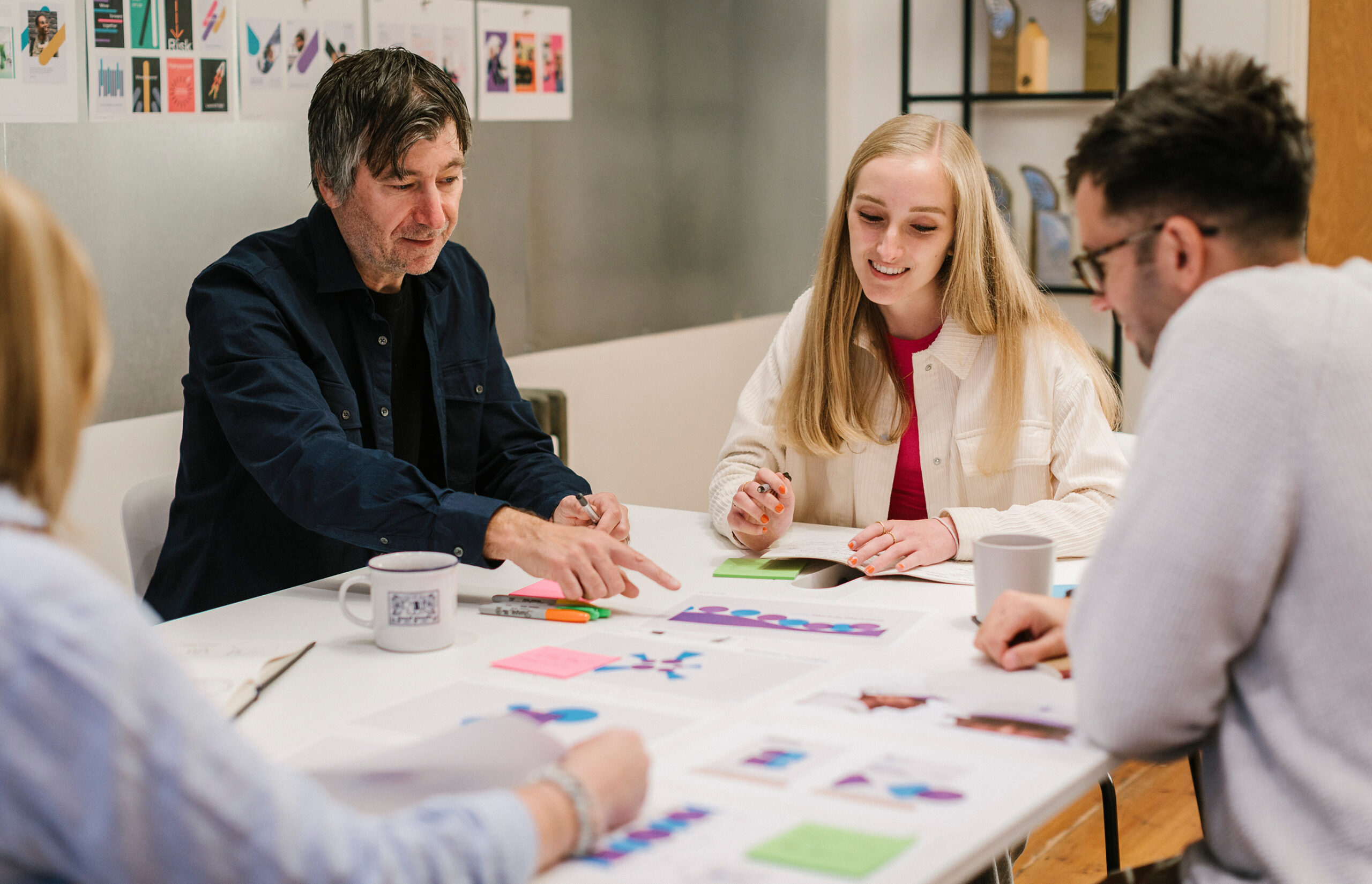 Meeting between designers discussing work over a table