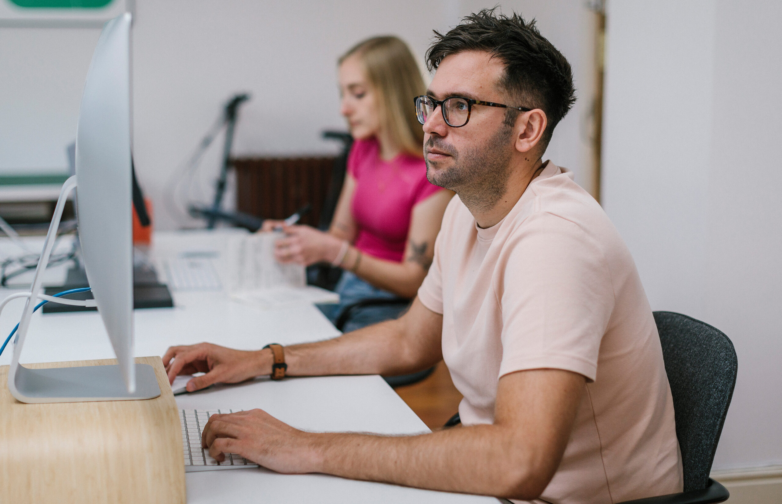 Designers sat at a desk focused on a computer screen